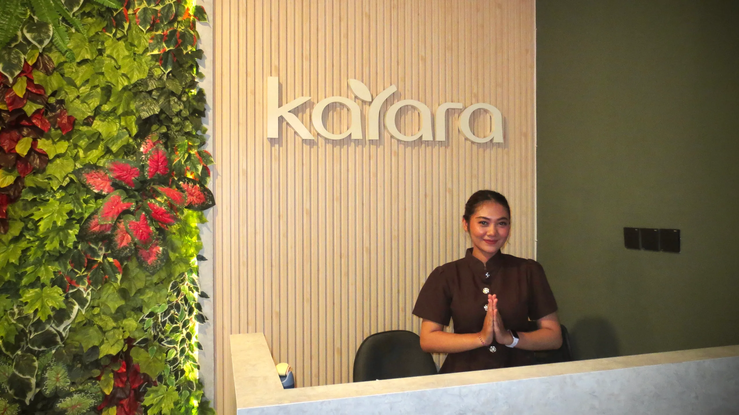 Resepsionis Kayara menyambut tamu di meja depan